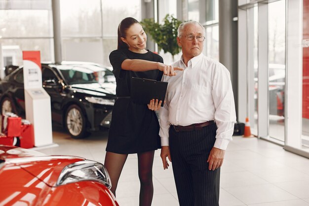 Stilvoller und eleganter alter Mann in einem Autosalon