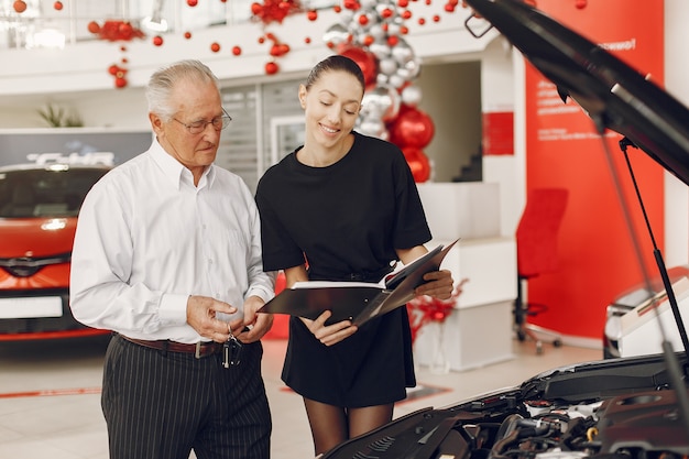 Kostenloses Foto stilvoller und eleganter alter mann in einem autosalon