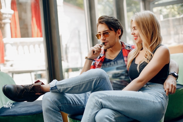 Stilvolles junges Paar mit Vape in einem Café