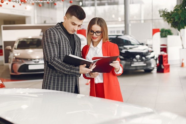 Stilvolles und elegantes Paar in einem Autosalon