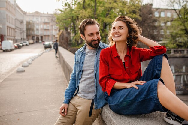 Stilvolles verliebtes Paar, das auf romantischer Reise in der Straße sitzt
