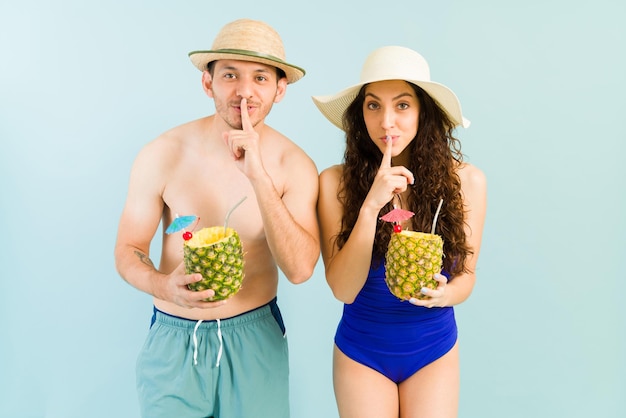 Stören sie nicht meine erholsamen ferien. attraktives junges paar in den zwanzigern, das während seiner tropischen reise einen pina-colada-cocktail am strand genießt