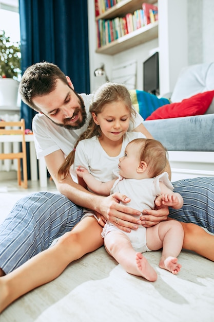 Stolzer Vater hält seine neugeborene kleine Tochter zu Hause