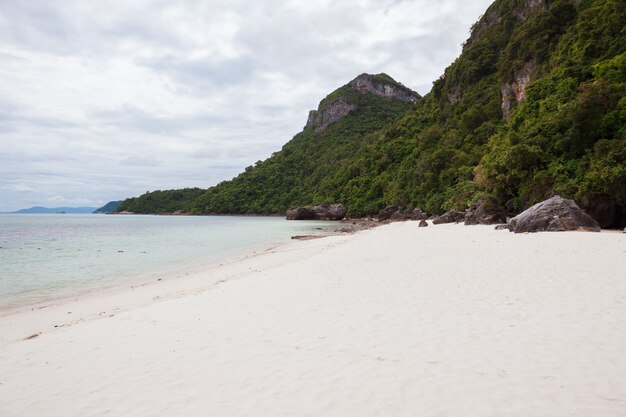 Strand auf tropischer Insel. Klares blaues Wasser, Sand, Wolken.