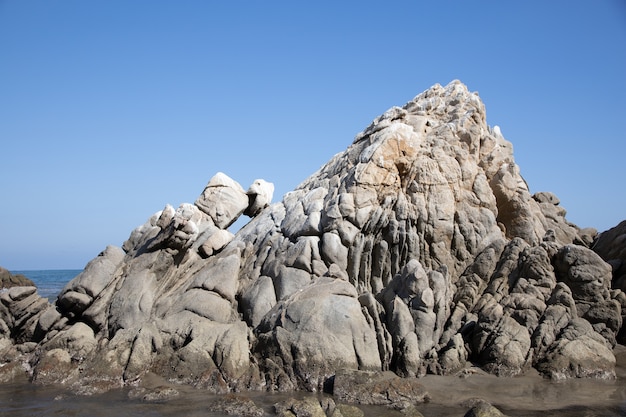 Strand bedeckt mit felsen, umgeben vom meer unter dem sonnenlicht und einem blauen himmel in mexiko