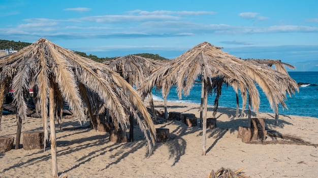 Strand der Ägäis mit Regenschirmen aus Palmenzweigen in Griechenland