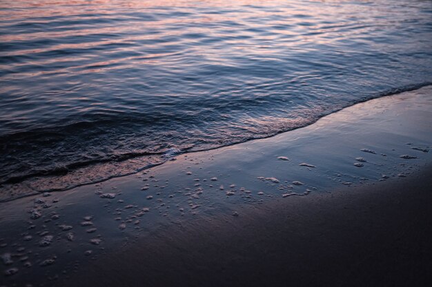 Strand umgeben vom Meer unter dem Sonnenlicht während des Sonnenuntergangs