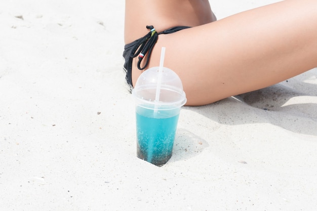 Was Hat Mehr Zucker Cola Oder Eistee Strandfrau, die kaltes getränkgetränk trinkt und spaß bei der