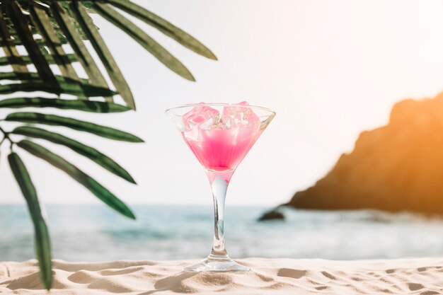 Strandhintergrund mit rosa Cocktail