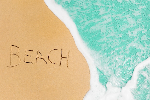 Strandkonzept mit dem Strand geschrieben in Sand