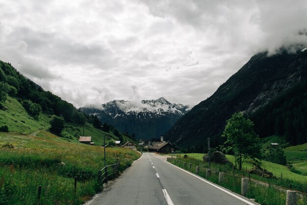 Straße in den Schweizer Alpenbergen im bewölkten Wetter des Sommers