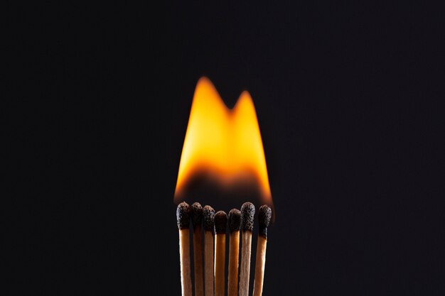 Streichhölzer brennen mit dunklem Hintergrund
