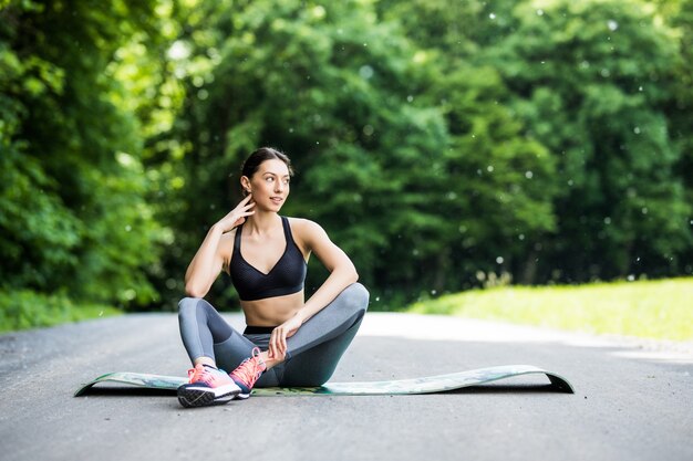 Stretching Frau in Outdoor-Übung lächelnd glücklich Yoga macht Strecken nach dem Laufen.