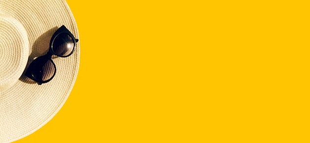 Strohhut mit Sonnenbrille auf Gelb