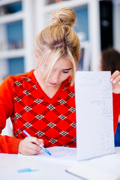 Student, der Berechnungen auf Notizbuch macht