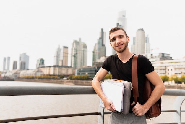 Kostenloses Foto student in einer großstadt hält seine notizen