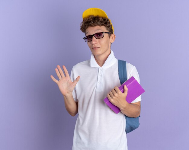 Student in weißem Poloshirt und gelber Mütze mit Brille