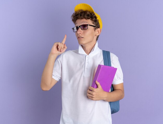 Student in weißem Poloshirt und gelber Mütze mit Brille