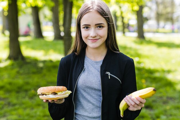 Student posiert mit Banane und Burger