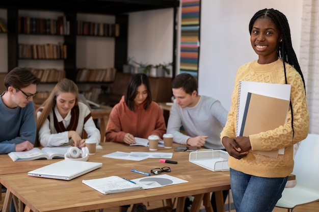 Student posiert während einer Gruppenstudie mit Kollegen