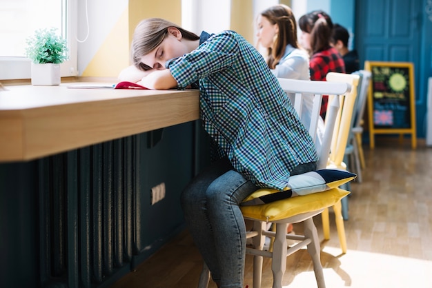 Student schläft am Schreibtisch