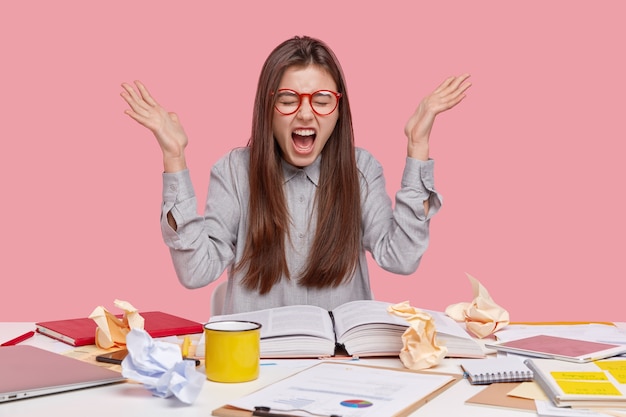 Kostenloses Foto student sitzt am schreibtisch mit dokumenten