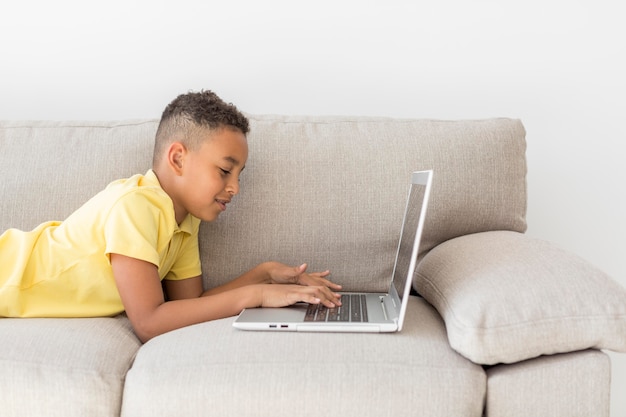 Student sitzt auf der Couch mit Laptop