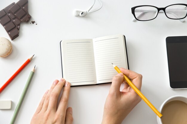 Student weibliche Hände halten einen Bleistift und öffnen Notebook