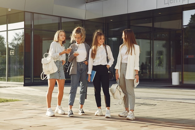 Studenten auf dem Campus mit Büchern und Taschen