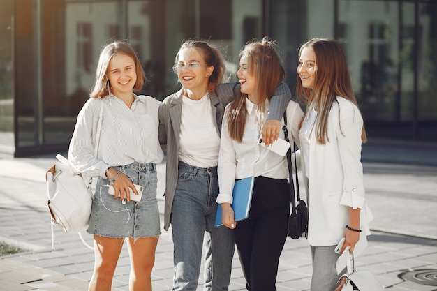 Studenten auf dem Campus mit Büchern und Taschen