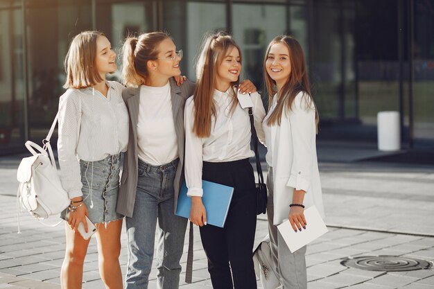 Studenten auf dem Campus mit Büchern und Taschen