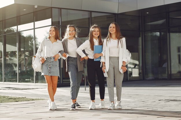 Studenten auf dem Campus mit Büchern und Taschen