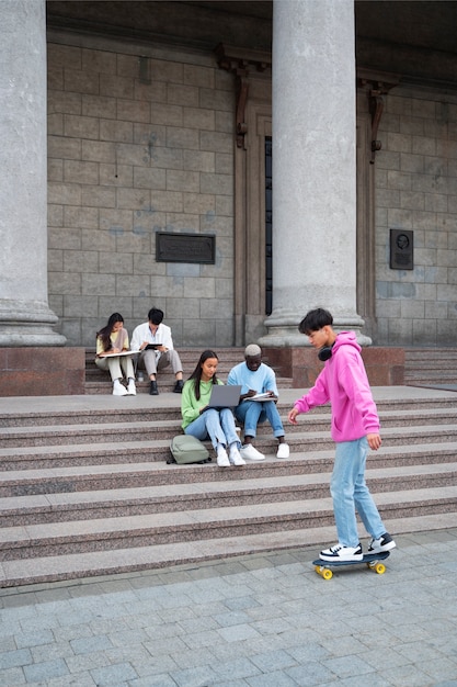 Kostenloses Foto studenten, die auf der treppe lernen, volle aufnahme