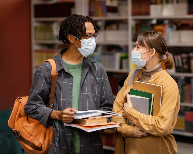 Studenten, die medizinische Masken in der Bibliothek tragen