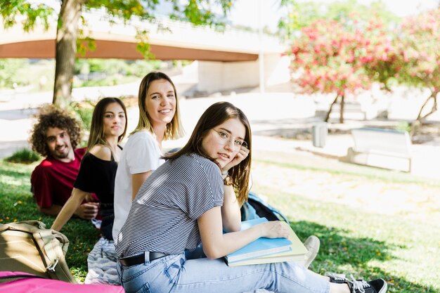 Studenten im Park, der Kamera betrachtet