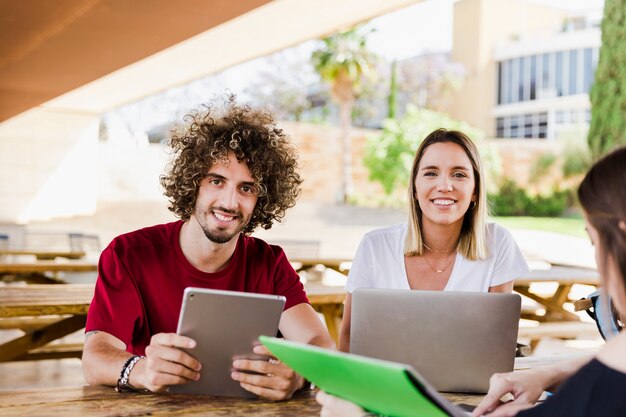 Studenten mit dem digitalen Gerät, das Kamera betrachtet