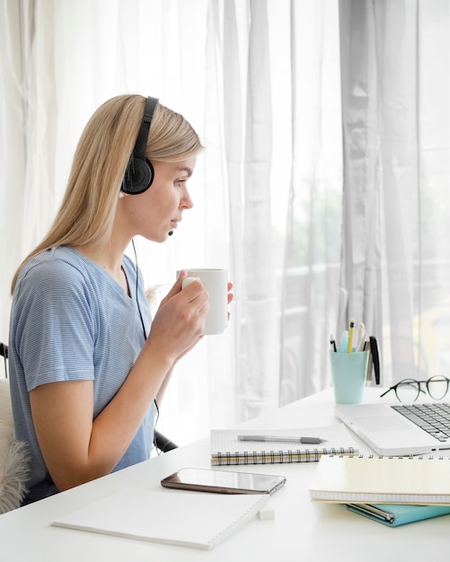 Studentin der Seitenansicht, die ihren Morgenkaffee trinkt