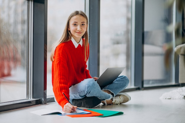 Studentin, die am Computer am Fenster studiert