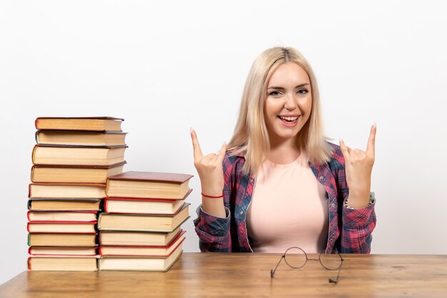 Studentin, die gerade mit Büchern auf Weiß sitzt