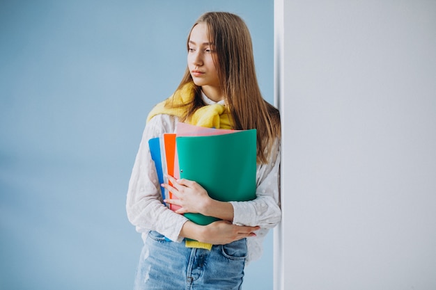 Studentin, die mit bunten Ordnern steht