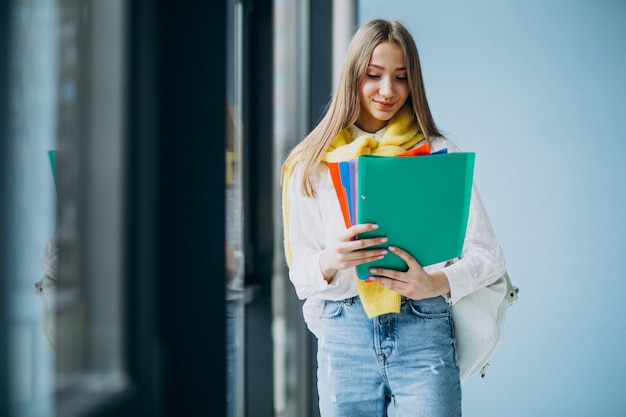 Studentin, die mit bunten ordnern steht