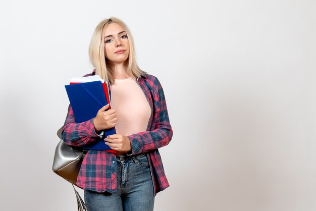 Studentin, die verschiedene Dateien auf Weiß hält