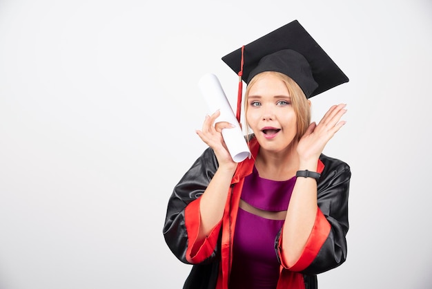 Studentin im Kleid erhielt Diplom auf weißem Hintergrund. Hochwertiges Foto