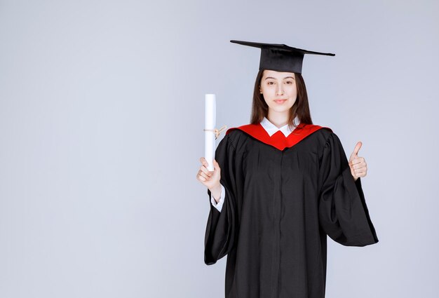 Studentin mit College-Diplom posiert vor der Kamera. Foto in hoher Qualität