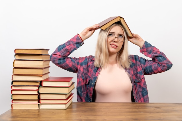 Studentin sitzt mit Büchern auf weißem Boden Schule Lesebuch Wurm Studentenbibliothek Buch