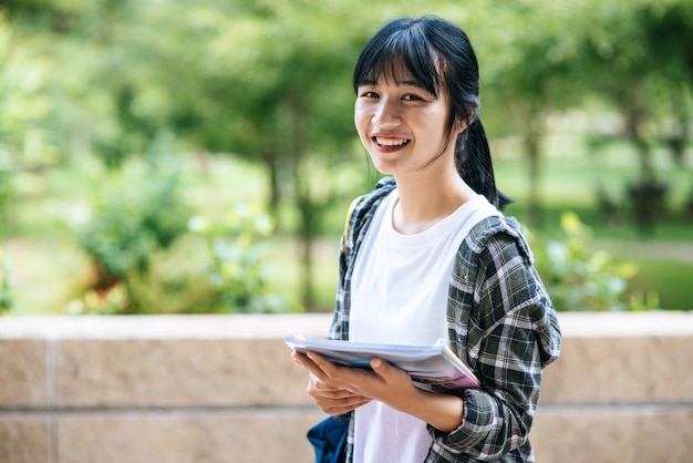 Studentinnen stehen auf der Treppe und halten Bücher.