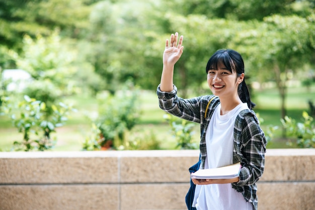 Studentinnen stehen auf der Treppe und halten Bücher.