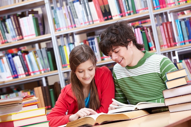 Studierende mit dem Tisch voller Bücher