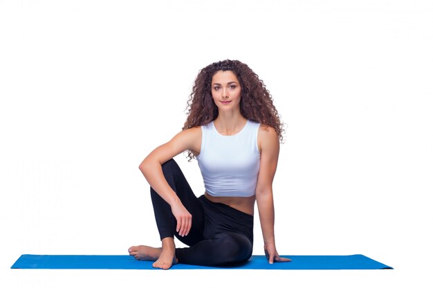 Studioaufnahme einer jungen fitten Frau, die Yogaübungen macht.