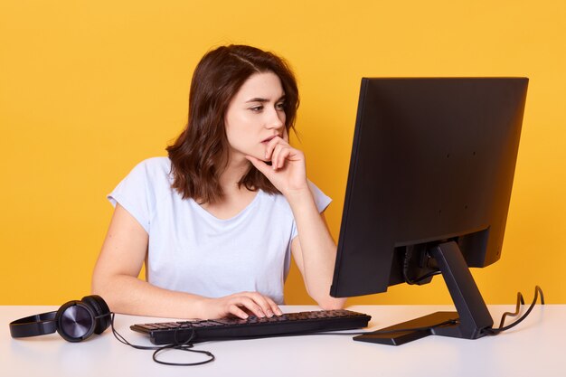 Studioaufnahme eines angenehm aussehenden Studenten mit konzentriertem Blick